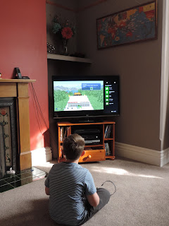 boy playing minecraft on x-box console