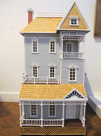 Four-story dolls' house, on display in a gallery.