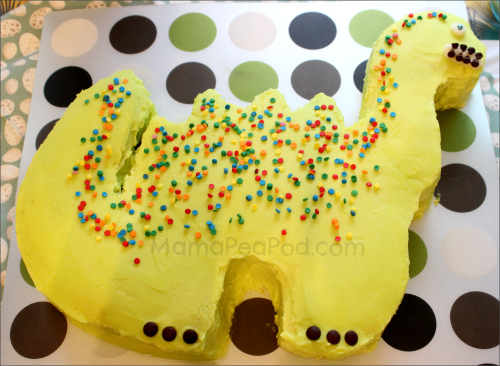 green dinosaur shaped birthday cake with colourful confetti sprinkles