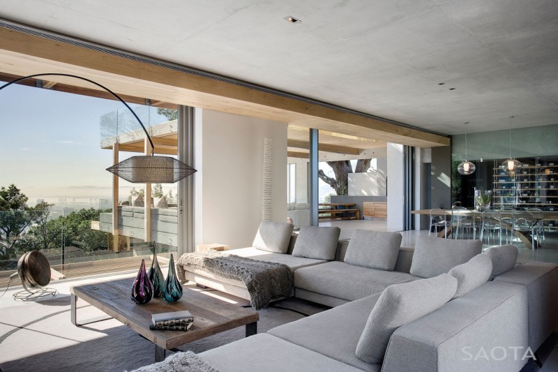 Photo of modern living room interiors with white couch by the large glassy doors to the terrace