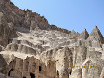 Cradle of pinnacles in various stages of erosion, from cap to shark fin to pinnacle, Cappadocia