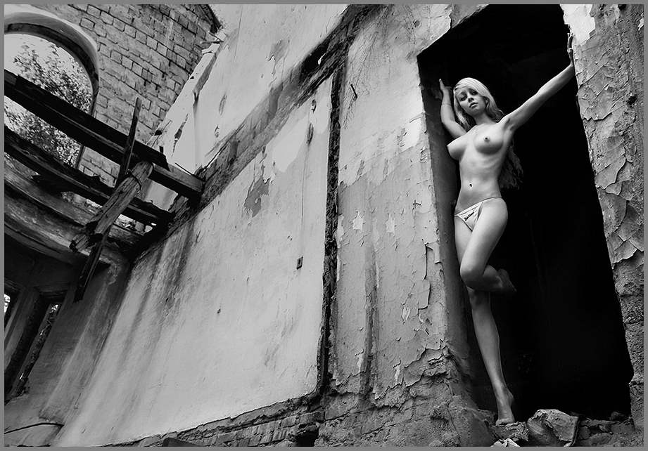Молодая девушка позирует голая среди древних развалин