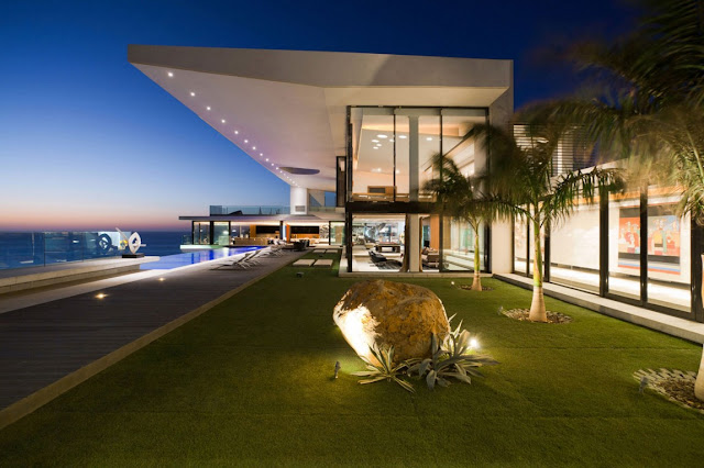 Picture of dream home as seen from the lawn by the house at sunset