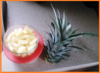 Cut pineapple pieces inside glass bowls on left, one long stem with leaves on right.