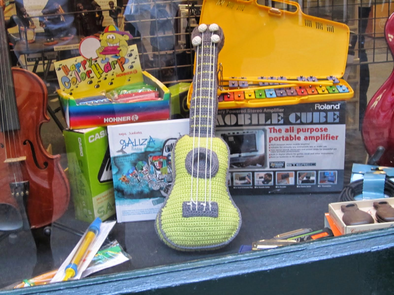 100 desconocidos posando con un ukelele de ganchillo