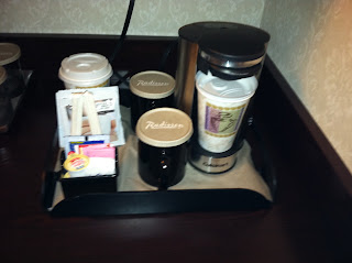 a coffee maker and coffee mugs on a tray