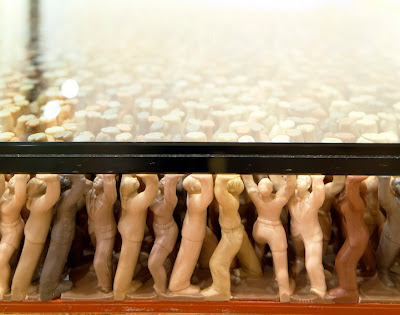 close up side view of figures holding up floor