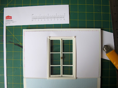 Cardboard template on top of a Lundby Smaland dolls' house wall with French doors.