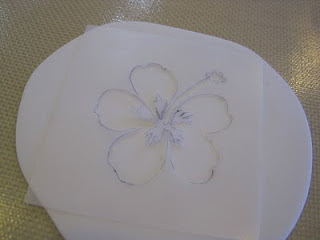 Hibiscus stencil over a piece of rolled out white fondant