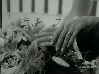 black and white picture of a man and woman's hands bearing wedding bands