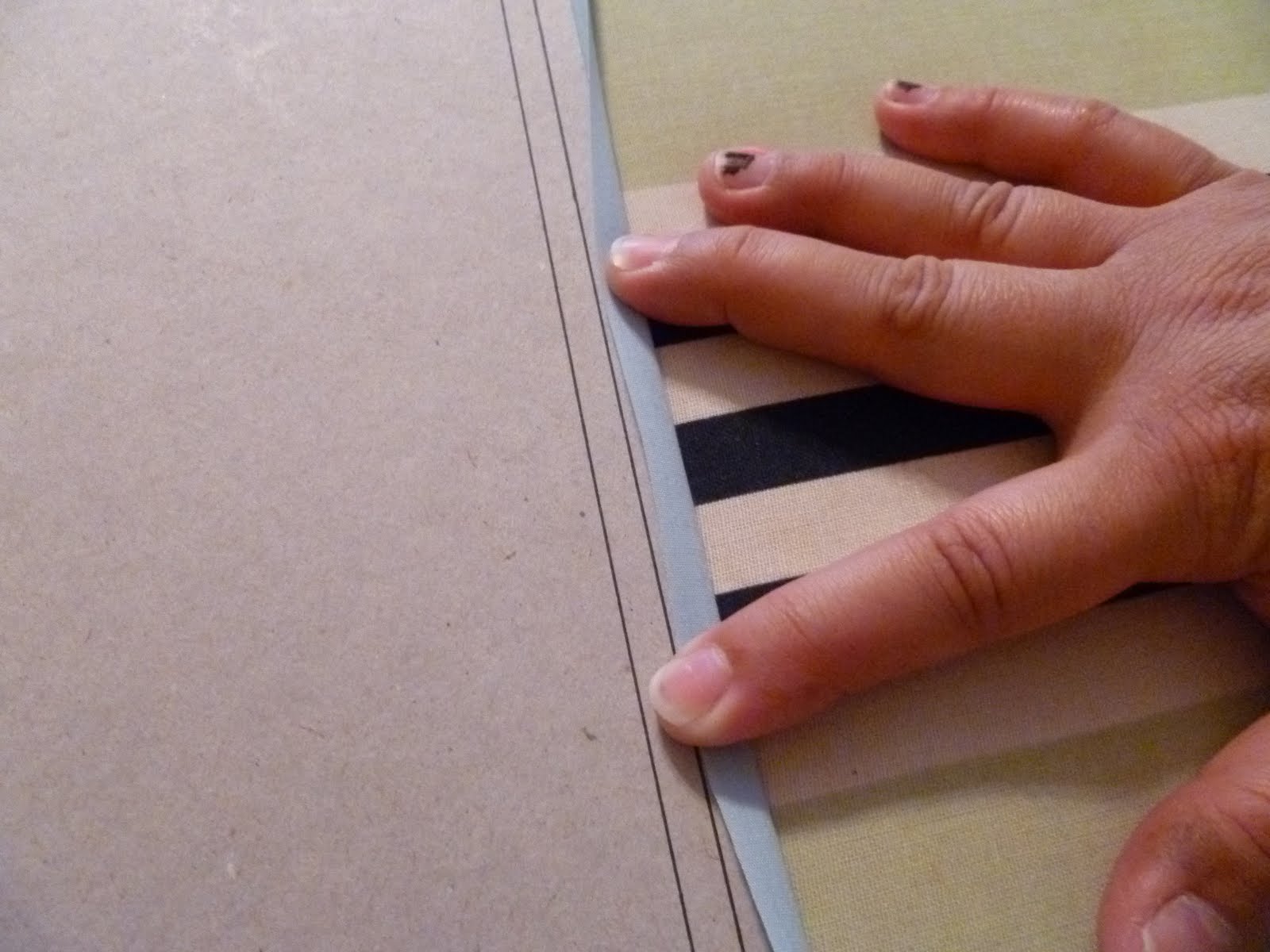Lay the chipboard on the wrong side of the fabric near the edge you are