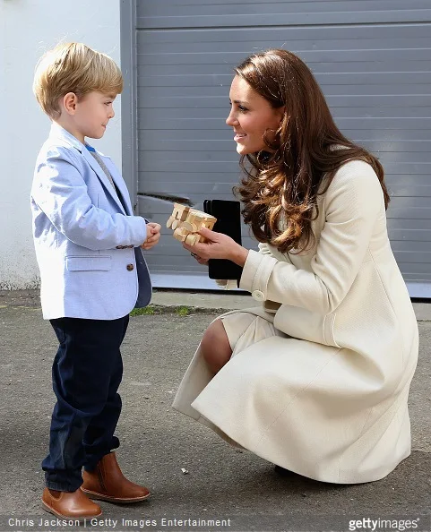  Catherine, Duchess of Cambridge is presented with a train for Prince George by actor Oliver Barker during an official visit to the set of Downton Abbey