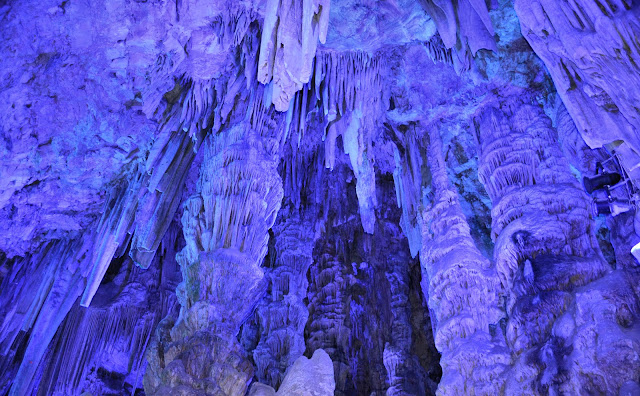The vast chambers of Saint Michael's Cave were illuminated in a kaleidoscope of artificial light, ever-changing hues bathing the stalactites and stalagmites in vibrant radiance.
