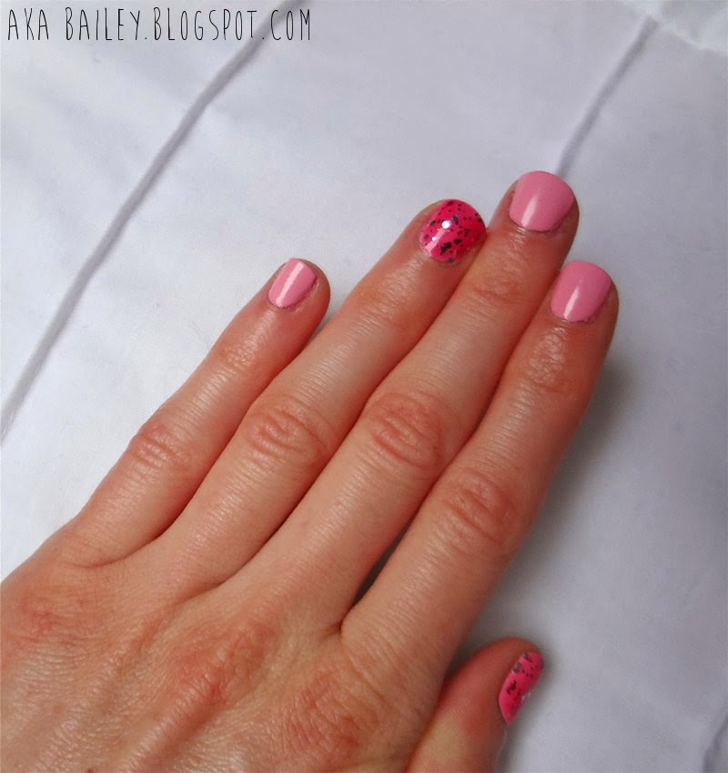 Pastel pink nails with multi-colored glitter accent nails