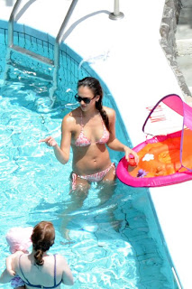 Jessica Alba pointing at something while in the pool