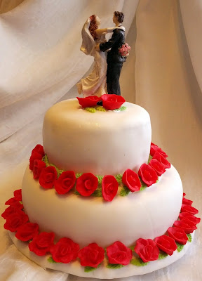 Mini-bolo de casamento, decorado com pasta americana e flores modeladas, massa branca e recheio de brigadeiro.