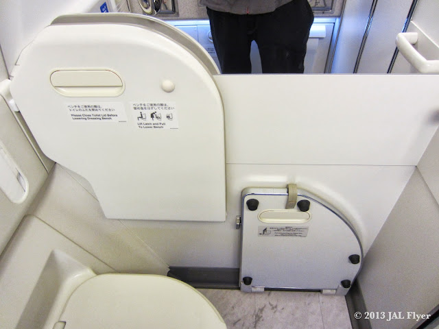 JAL F lavatory - You can pull down the board to cover the floor when you change your clothes