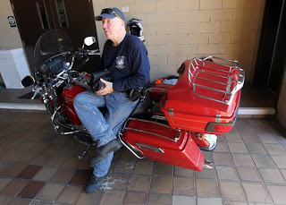 Bob Damron sits on his Harley-Davidson motorcycle, which he is riding on a 49 state tour to raise awareness of prostate cancer