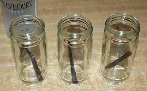 Whole vanilla bean being placed into spice jars