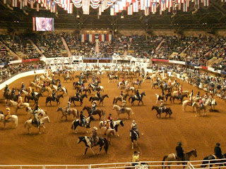 a large arena with people riding horses