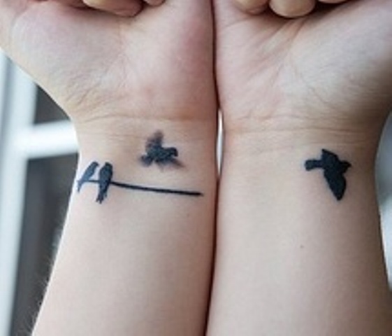 Flying black small birds tattoo on wrists