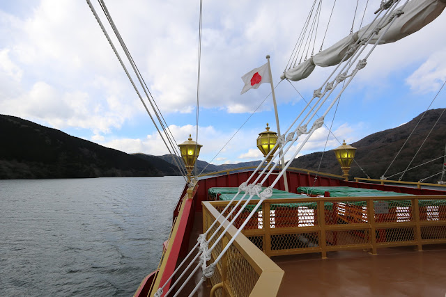 The rear view of Hakone Sightseeing Cruise ship with Japan flag along Lake Ashinoko in Japan The rear view of Hakone Sightseeing Cruise ship with Japan flag along Lake Ashinoko in Japan