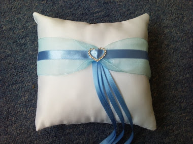 white ring cushion with blue ribbon and silver heart £8.50