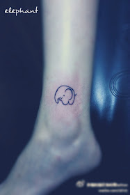 a cute little comic style elephant tattoo on the leg
