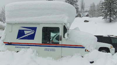 USPS mail truck covered in four feet of snow