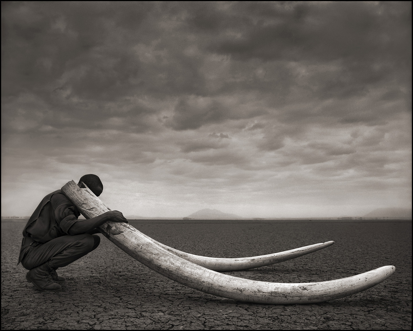 ©Nick Brandt, Ranger with Tusks of Dead Elephant, Amboselli, 2011.