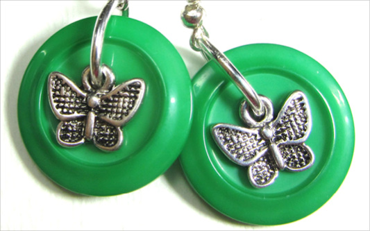 Flirty Charm Earrings Drop dangle earrings have silver butterfly charms layered over green fashion buttons