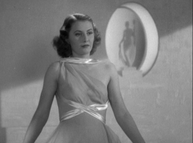 Barbara Stanwyck models an evening gown in the film.