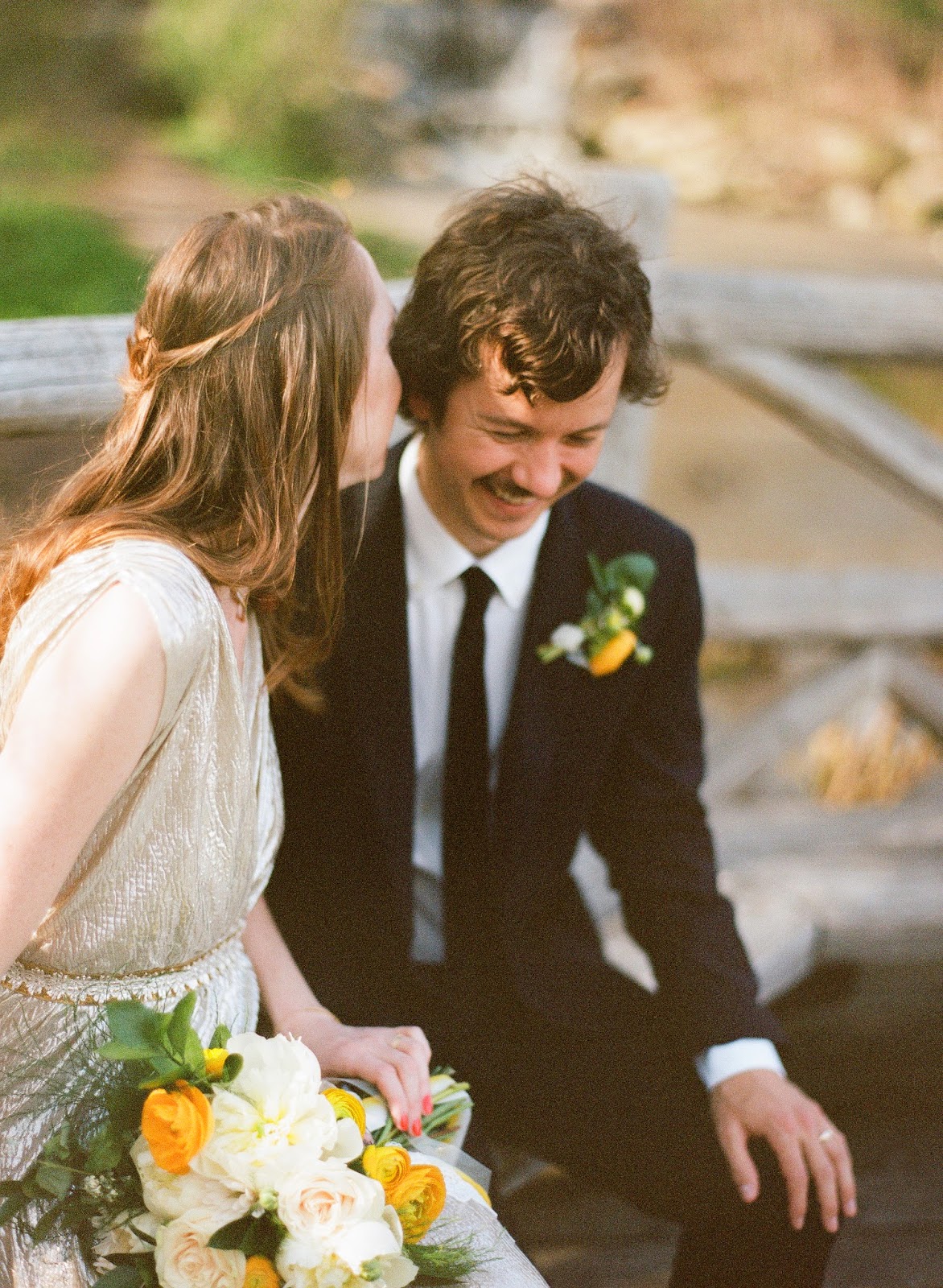 intimate moment between bride and groom in prospect park, brooklyn, new york with yellow ranunculus and white peony spring bouquet and boutonniere