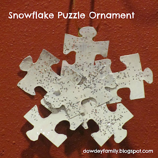 ornament made from puzzle pieces, paint and glitter to look like a snowflake