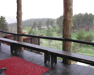 Pellets of hail on a red carpet and a wet deck at the Colorado Mountain Ranch