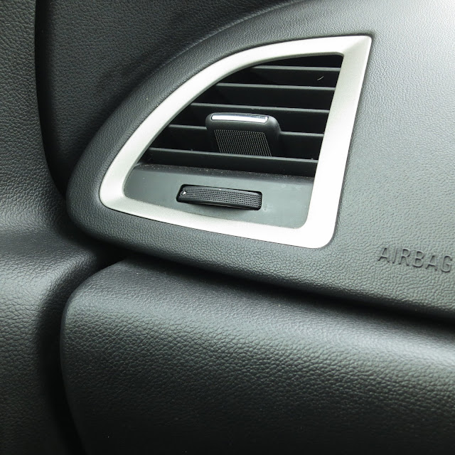Adjustable air vent and airbag case in passenger side of car.Black and silver.