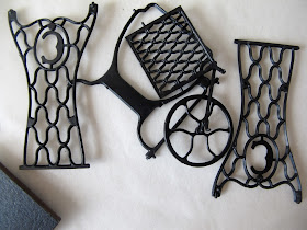 Pieces of a dolls' house miniature treadle sewing machine kit strewn on a tabletop.