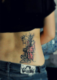 A tattoo featuring a fairy with pink wings by a tree