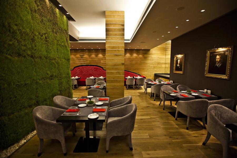 Picture of square dining tables by the green wall with living grass