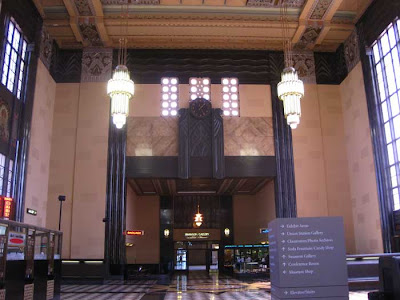 The main train station hall from floor to ceiling, showing the chandeliers and windows