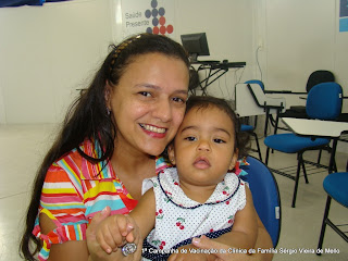 Nossa paciente sorri com a filha nos braços minutos após ser imunizada.