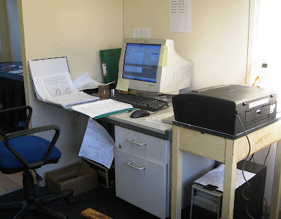 Computer and paperwork on desk with printer