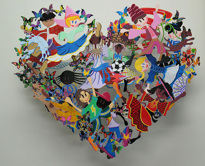 A colorful David Kracov sculpture that uses cut outs of children and butterflies to create a heart
