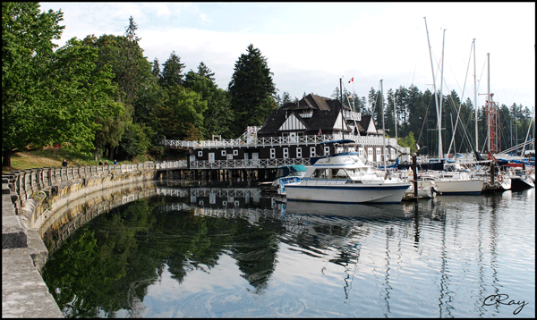 view of Vancouver Rowing Club building with seawall and water reflections in Stanley Park, Vancouver