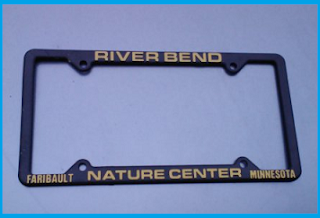 Black license plate frame, letters are yellow: RIVER BEND (on top), NATURE CENTER (centered below).  Faribault and Minnesota on the lower left and right sides, respectively