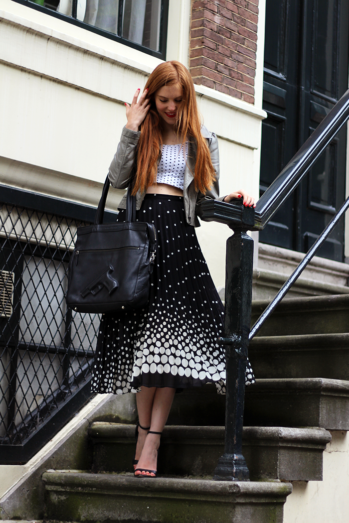 Vintage fashion blogger outfit with polka dots, pleated midi skirt and gun bag