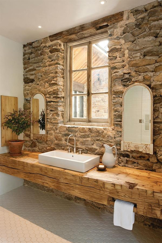 Bare stone wall bathroom. Photo by Lara Swimmer via Custom Homes.