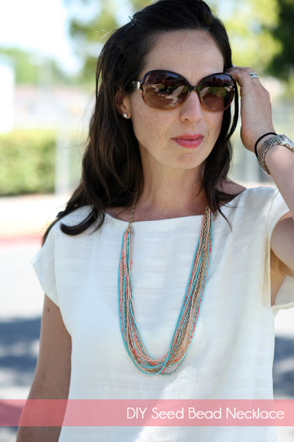 Andrea wearing a white tshirt, sunglasses, and a multi-strand seed bead necklace