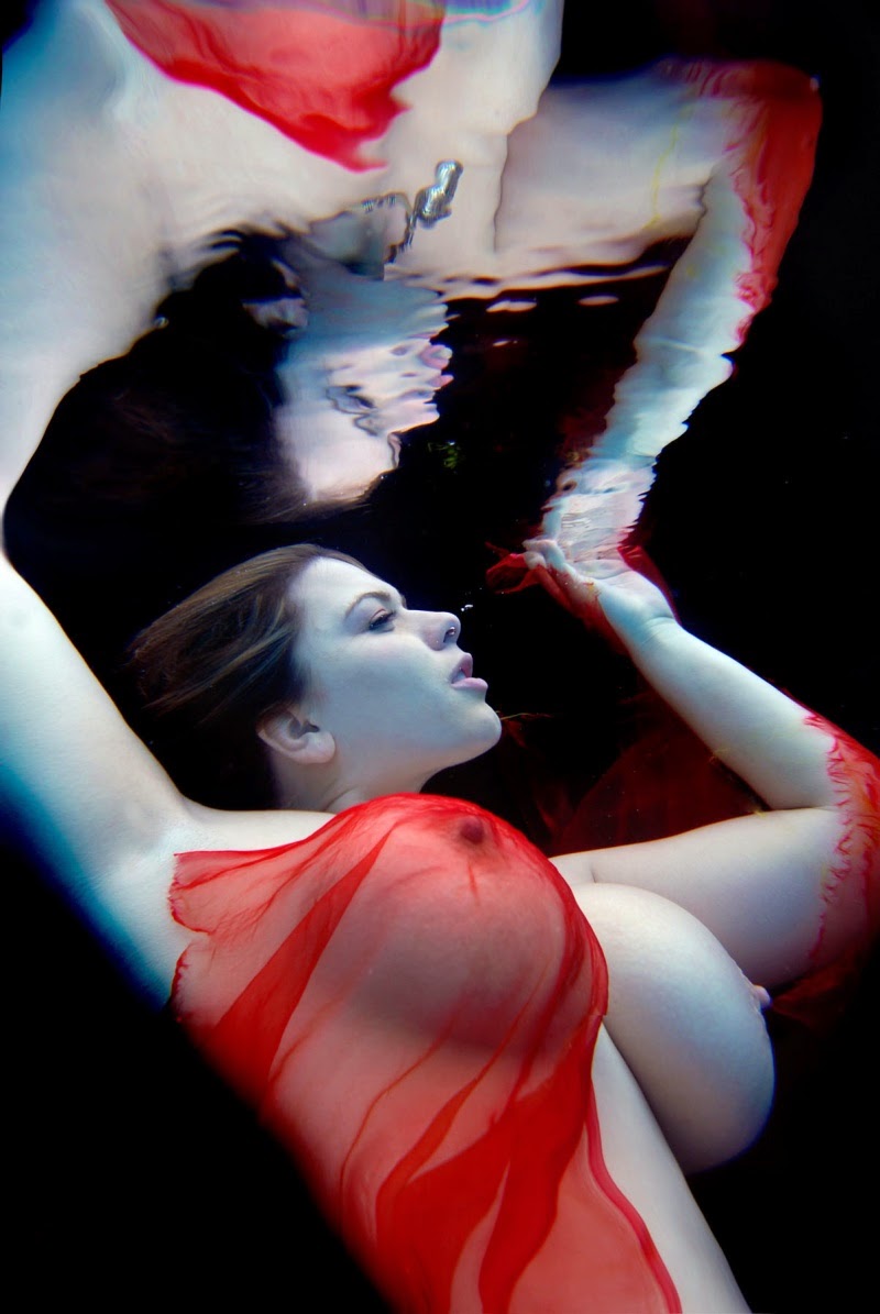 London Andrews nue sous l'eau un voile rouge effleurant un sein 