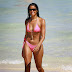 Real Housewife Claudia Jordan wears tiny string bikini while frolicking in the Miami surf